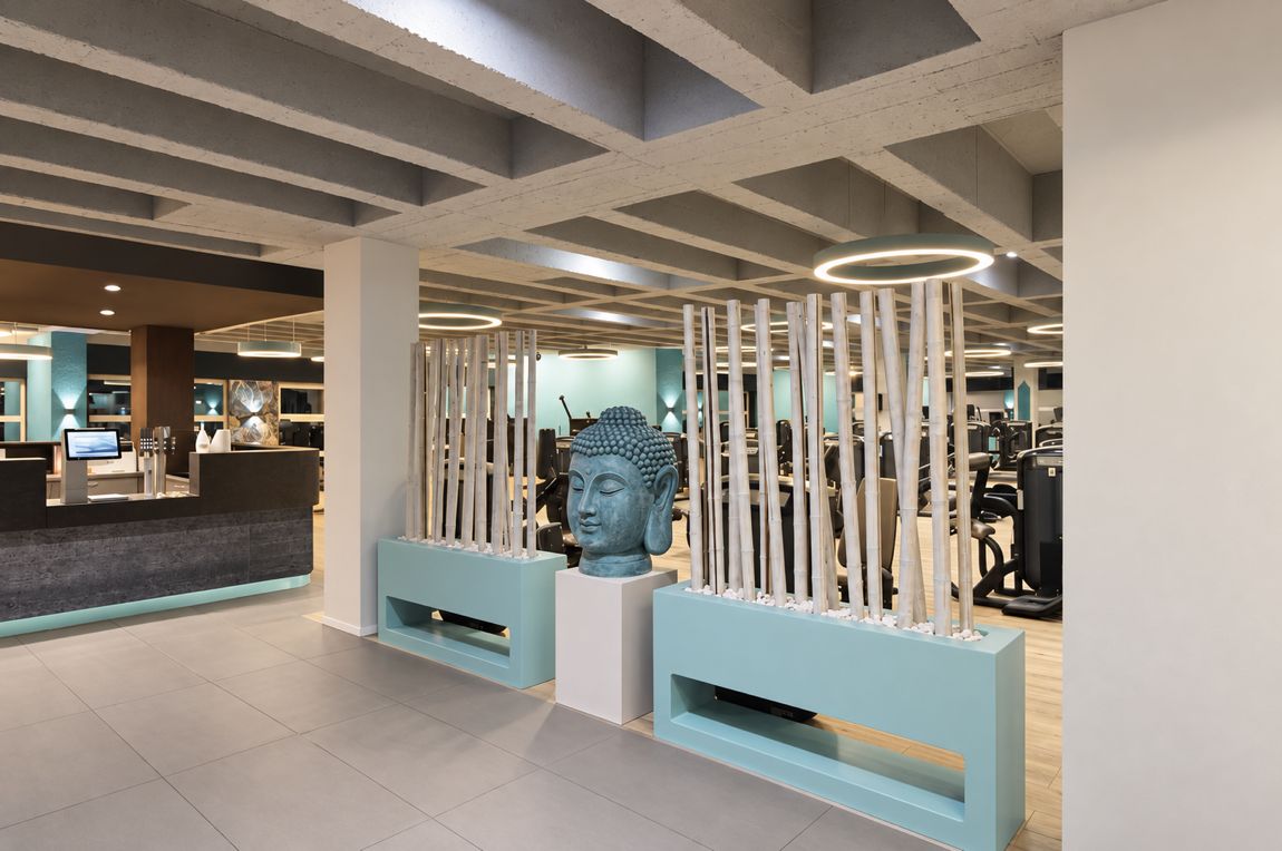 Empfangsbereich des Studios mit Buddha-Figur, Lamellenwand und Lichtring